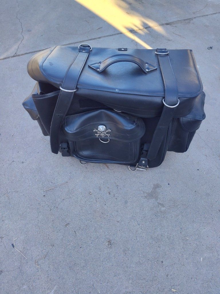 The item in the image is a motorcycle touring bag, also known as a sissy bar bagThe bag has a two-piece design, featuring a large main bag and a small