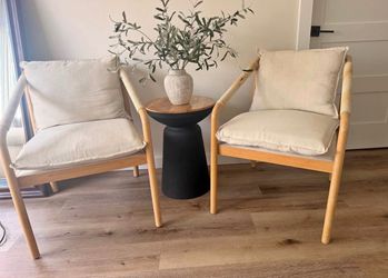 Modern pair of accent chairs with light-toned wood frames.