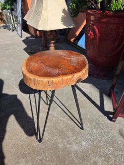 The side table features a natural live-edge wood top supported by three metal hairpin legs.