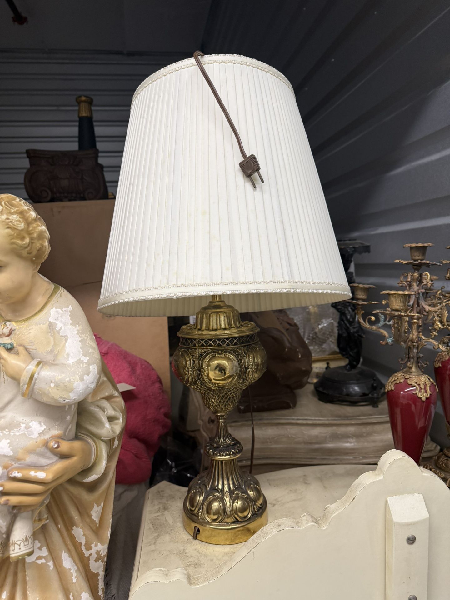 Ornate brass-toned table lamp with pleated shade.
