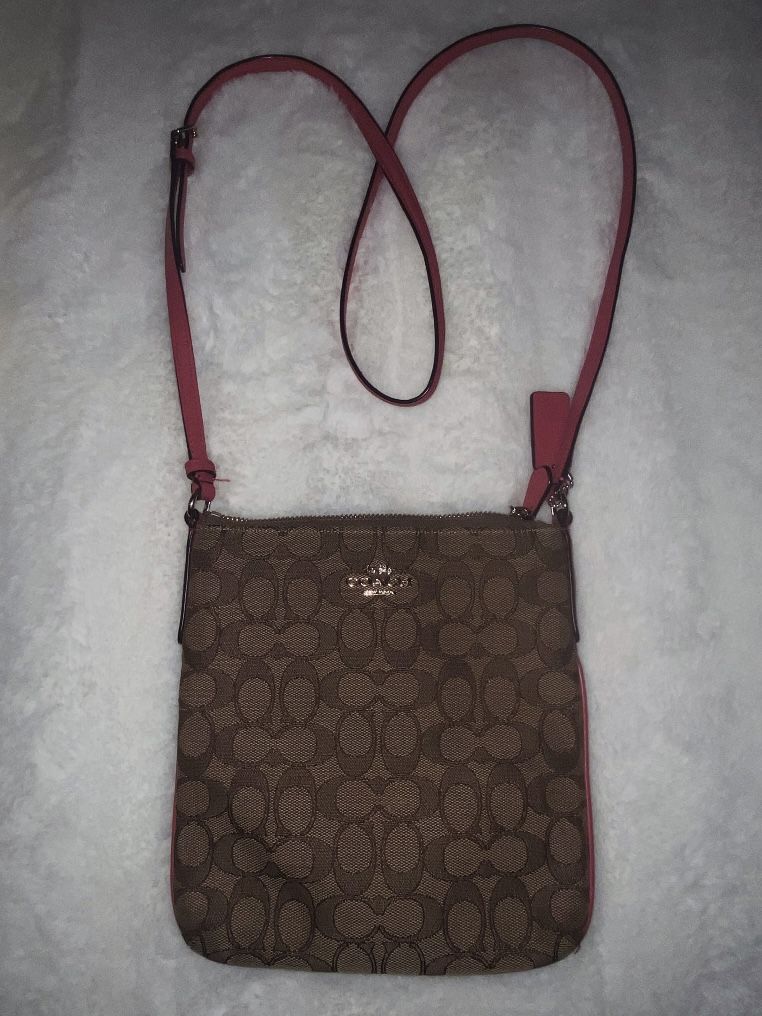 Coach F58309 Signature North South Crossbody bag in brown coated canvas with pink or fuchsia leather trim and strap.