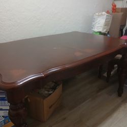 solid wood dining table with a Queen Anne style curved top and carved legs