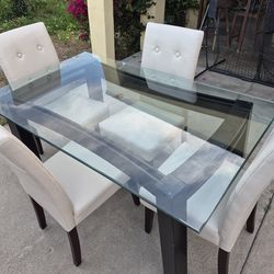 Glass top dining table and white chairs