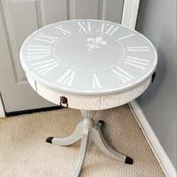Vintage round table with crackled edges and distressed legs. 

