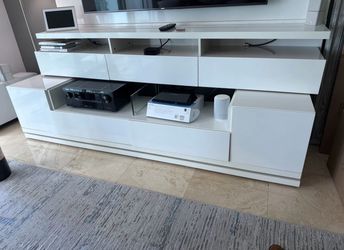 White high-gloss floating entertainment wall unit with built-in shelf, drawers, and open storage cubbies. Measures approximately 84” W x 67” H x 15” D