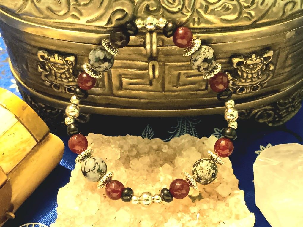 Obsidian Agit and Snowflake obsidian framed with silver colored fobs.
Medium size