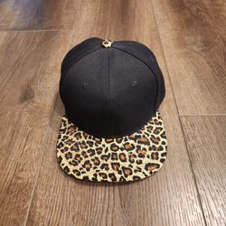 Flag & Symbol black snapback hat featuring a leopard print brim and button, good condition