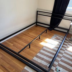 Black metal bed frame with wooden slats
