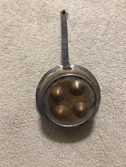 Antique copper colored egg pan with black handle