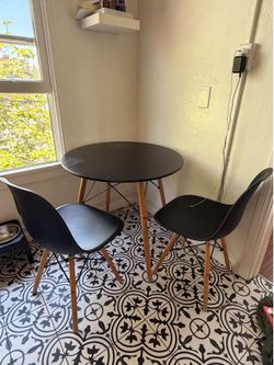 black round table and two matching chairs