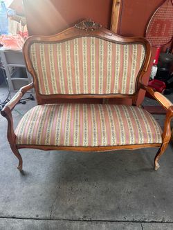 vintage or antique French Provincial style carved wooden settee/loveseat upholstered in a striped floral fabric