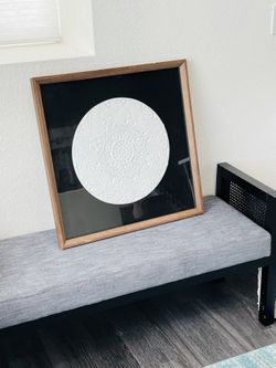 Elegant framed art with intricate circular design.