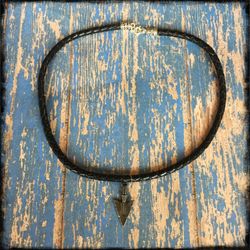 ** Men’s black leather necklace with metal accessories.