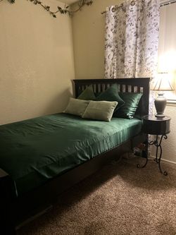 Black wooden queen bed and nightstand.