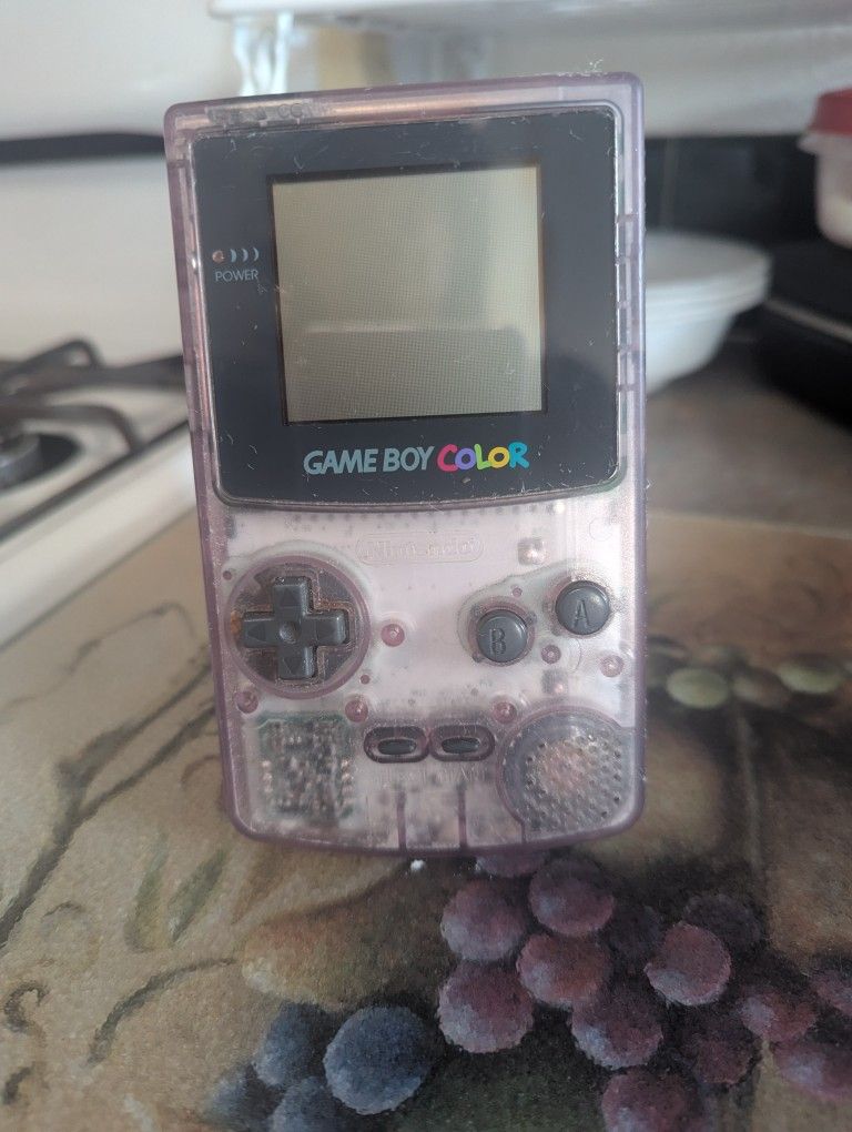 clear purple Nintendo Game Boy Color handheld console
The best I can tell you about this game boy console is that it does turn on with batteries but t