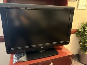 32 Inch Sharp AQUOS LCD TV bundled with Roku streaming stick and Roku remote.