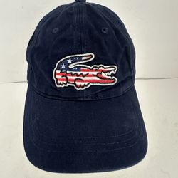 Lacoste Big Croc USA Gabardine Cap, a 6-panel cotton twill hat featuring an oversized embroidered crocodile logo with American flag detailing. 