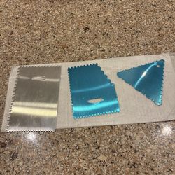 cake decorating tools, specifically aluminum cake scrapers and combs used for smoothing icing