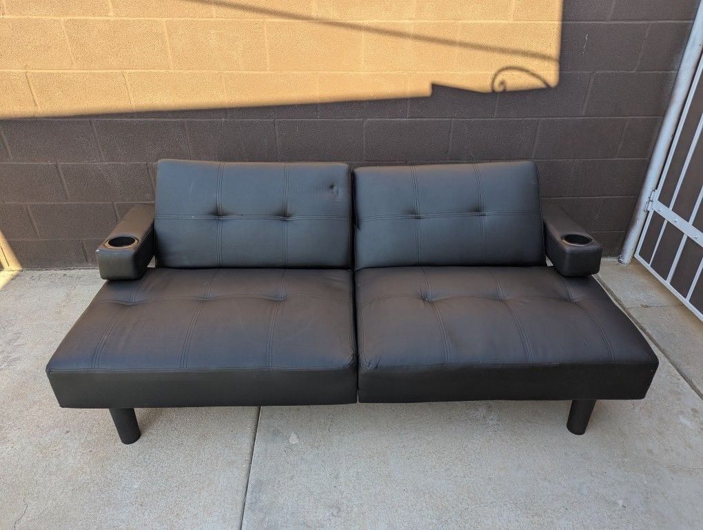 black leather futon with cup holders on each end
