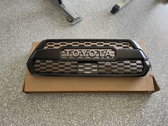 Toyota Tacoma TRD (3rd Gen) front grill with garnish (no hardware), and has a couple of broken clips.  Has some fading on the top.