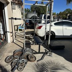 Bench press/squat rack with pulley systems and 7ft 45lbs bar plus 295lbs of Olympic weights and curl bar