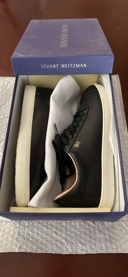 black leather Stuart Weitzman Cristy low-top sneakers featuring gold "SW" branding on the side 7.5