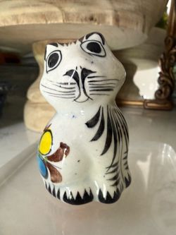 Cute ceramic cat figurine. Hand-painted with a pretty floral design on its side. Has black stripes. Great little decor piece for any cat lover.