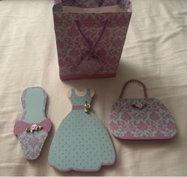 A set of decorative, die-cut paper pads shaped like a dress, shoe, and handbag