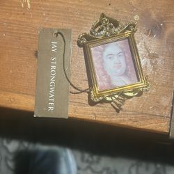 This item is a rare Jay Strongwater miniature bejeweled picture frame featuring an ornate, crystal-accented gold-tone metal crest.