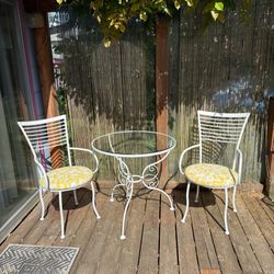 Wrought iron bistro set with two matching chairs