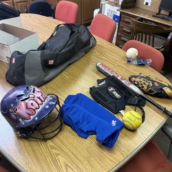 Girls softball bag with: bat, glove, helmet, ball, knee pads, and glasses.