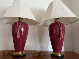 A pair of red ceramic lamps with white shade