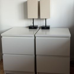 Two white IKEA nightstands with lamps