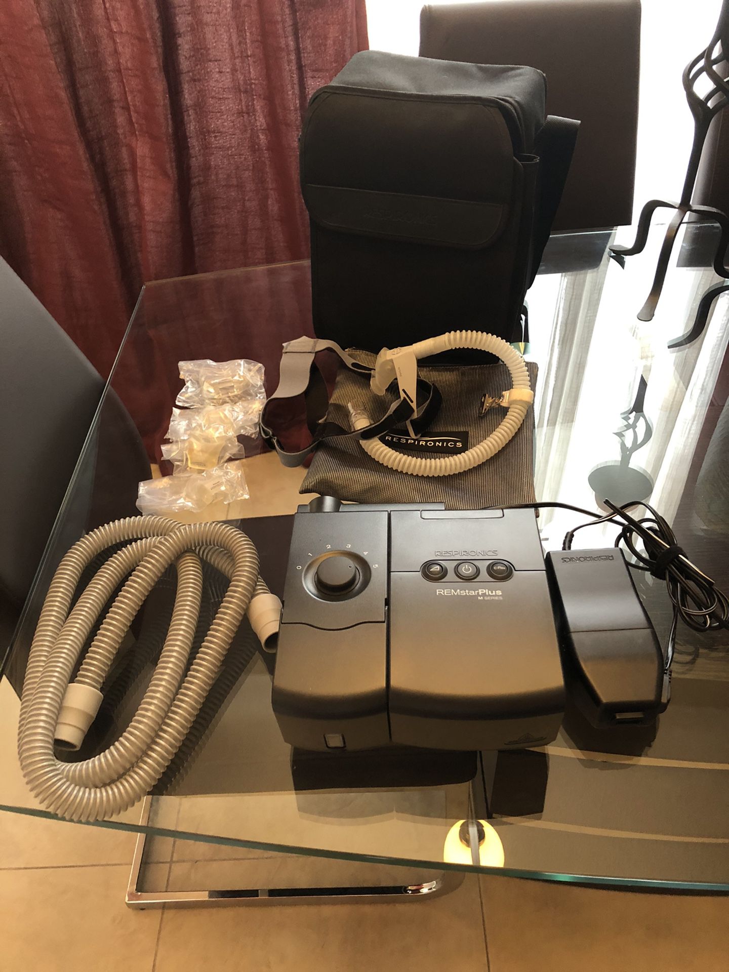 CPAP Machine Respironics with hose, nasal mask (different sizes), headgear, heated humidifier water chamber. Bag is included.