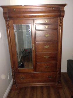 Antique Mahogany Armoire features a mirrored door and seven stacked drawers.