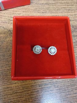 Diamond stud earrings with surrounding diamonds.