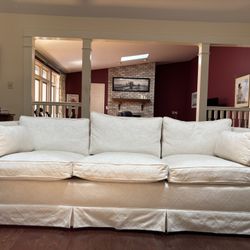 White Couch With feather filled pillows.