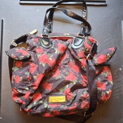 Betsey Johnson shoulder bag features a floral rose print and patent black handles. 
