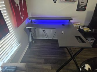 L shaped gaming desk with led lights and built in wireless charger and plugs