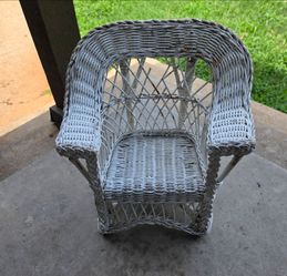 vintage white wicker chair for doll or teddy bear, featuring a curved back and armrests.