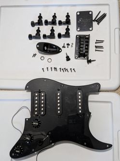 Loaded pickguard and black hardware from a Squier Strat