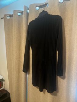 New Beautiful black ribbed knit Mini Dress. This long-sleeved garment has a mini length and a crew neckline. The fabric is a vertical ribbed texture t
