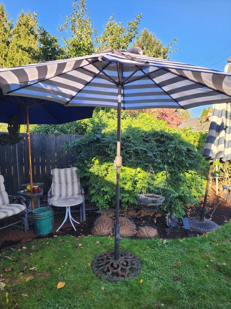 New 9' umbrella with crank and tilt mode in black and white with cast iron base. 