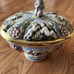 Vintage, hand-painted Capodimonte covered tureen featuring cherubs and floral motifs in relief.
