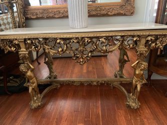 A 20th-century Baroque-style giltwood console table with a mirrored back.