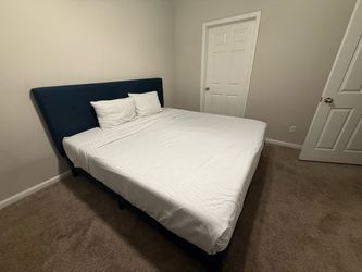 The bed with dark blue headboard and full base whit mattress. King Size