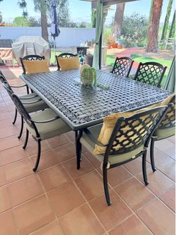 Large iron patio table with 10 chairs with cushions