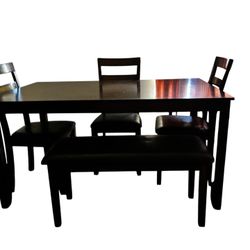 A Table With 3 Cheers And A Bench 