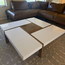 a modern engineered wood square coffee table with a white and brown finish.