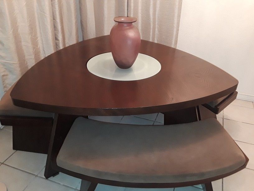 Wooden dinner table with benches (glass in the middle is a lazy susan)